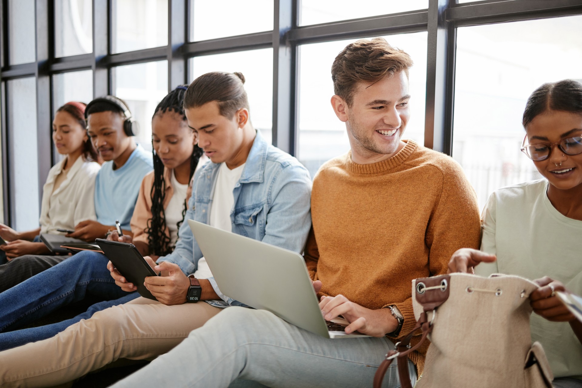 Nexodus Recruitment, hiring and students in waiting room for internship at startup company, talking and bonding on a floor. Interview, candidate and unemployed youth prepare for meeting with HR at agency