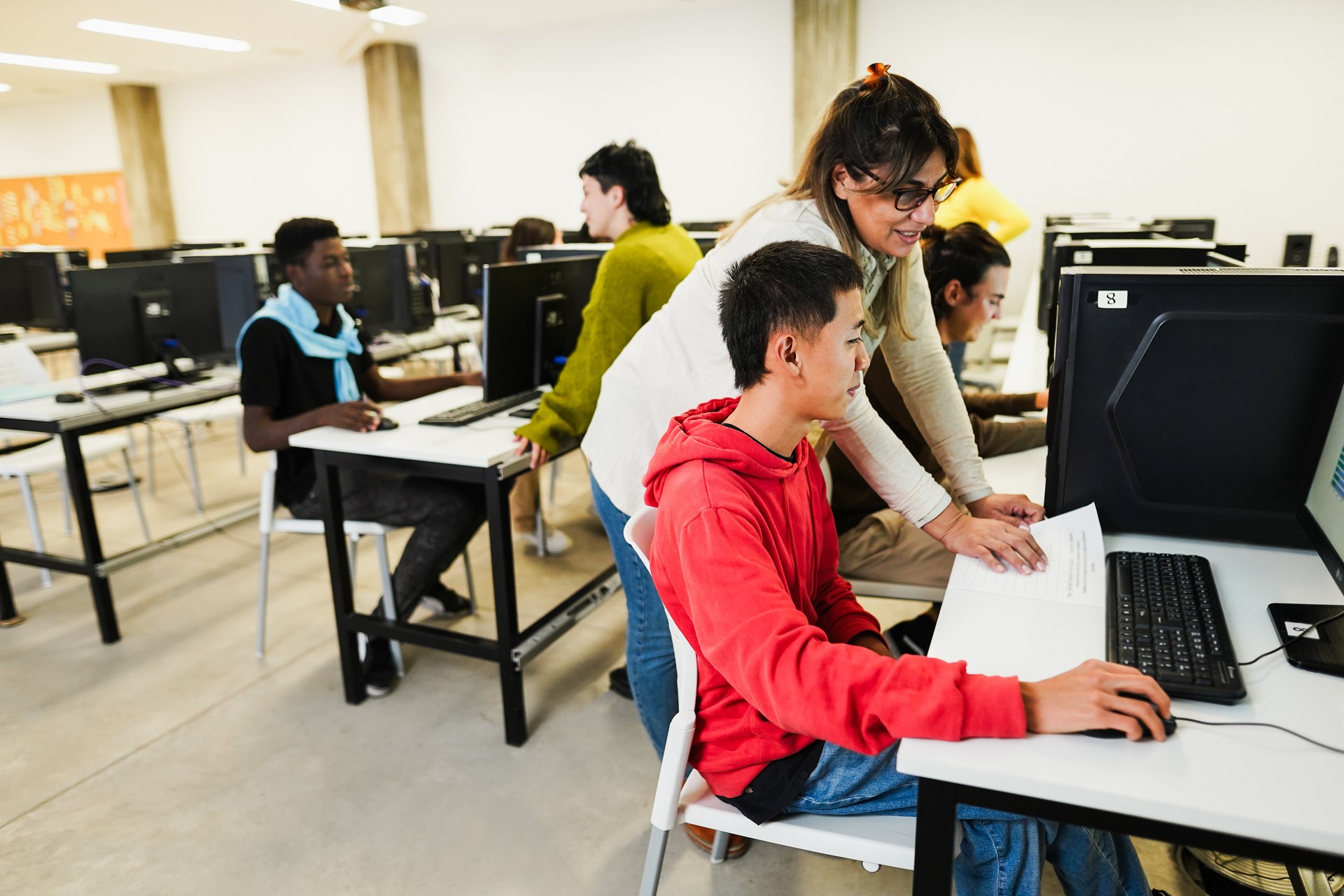 Students using computers softwares at college IT class - Woman teacher working at university - Back to school, learning and technology concept - Main focus on asian male face